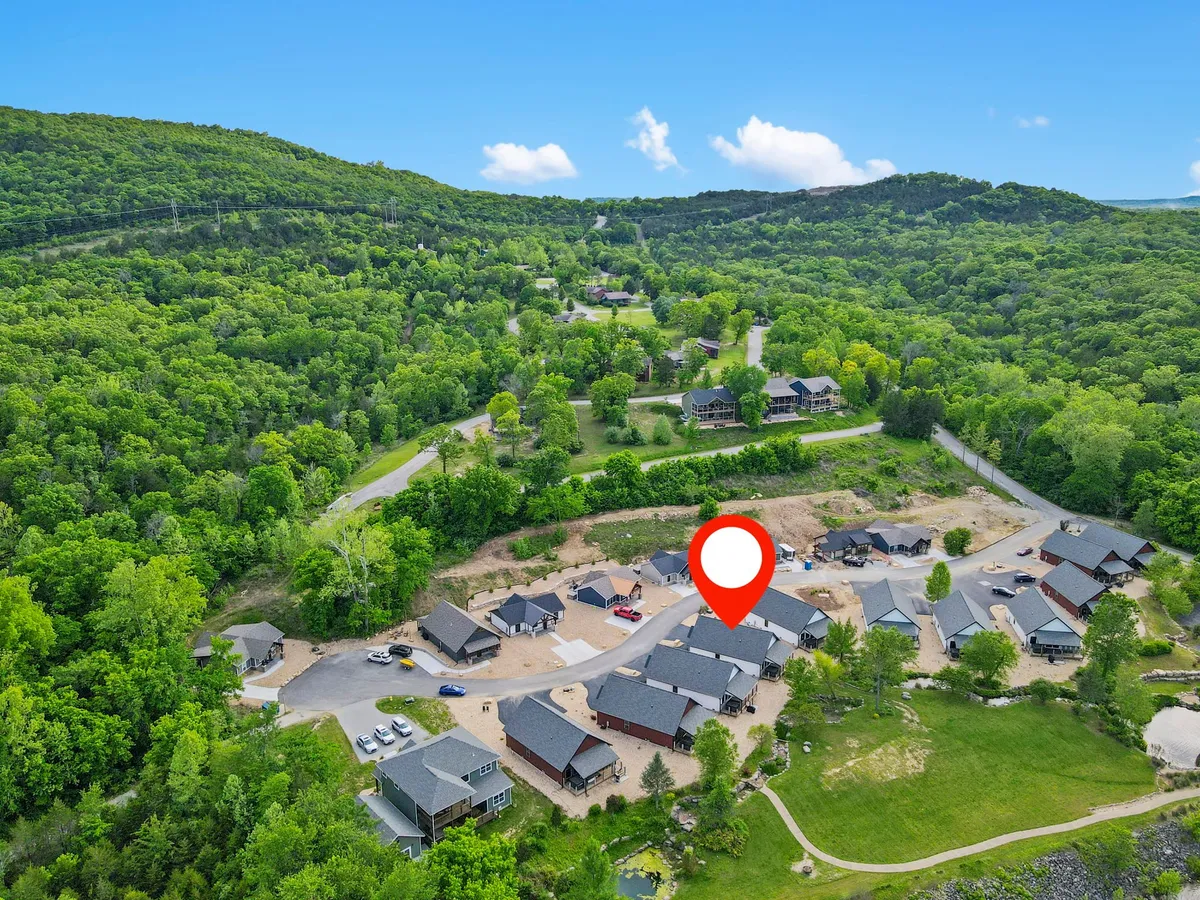 A sweeping view of rolling green hills dotted with houses and intersected by roadways, suggesting nearby trails, biking routes, and community activities. The expansive landscape invites exploration and active adventures.